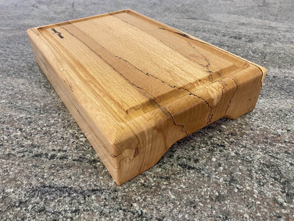 Close up angle view of this Extra thick Spalted Beech Chopping Board with a Continuous Crumb Groove, handcrafted by Crystal Woods from locally sourced wood in Devon, finished in food safe oil, branded with their logo stamp