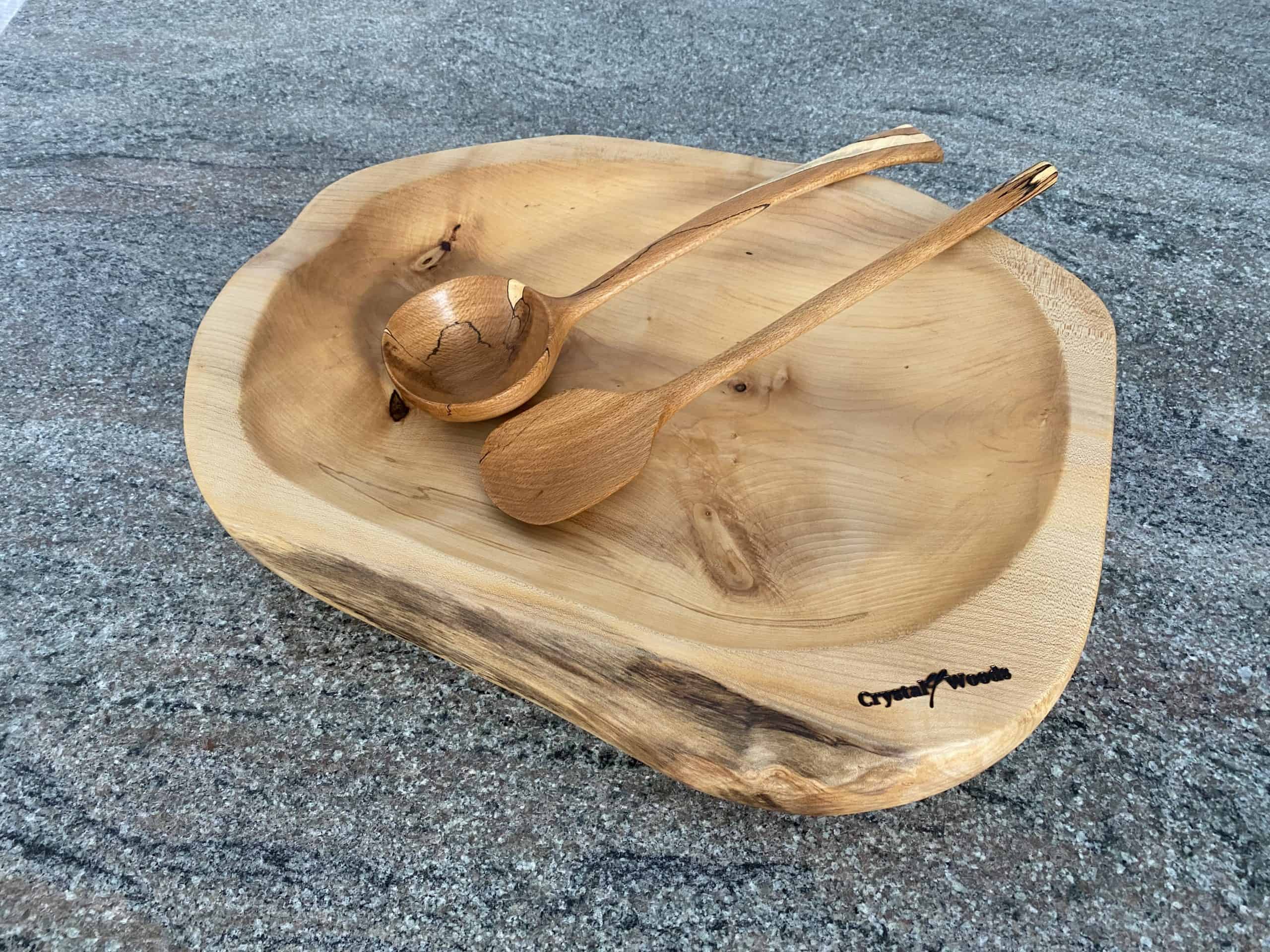 Large Hand Carved Sycamore Salad Bowl 2 Over view of this Large Sycamore Hand Made Salad Bowl, showing a decorative wooden spoon and ladle from Spalted Beech, locally sourced wood in Devon, produced by Crystal woods and branded with their logo stamp, finished in food safe oil