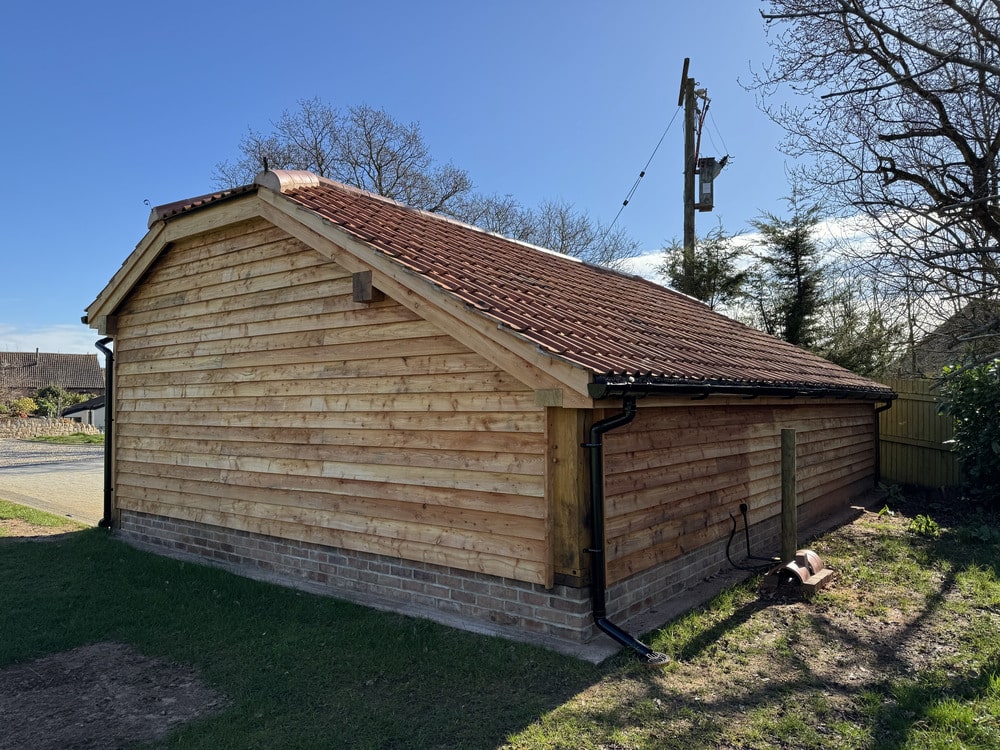 Oak Framed Gazebos 4 side view of an oak frame garage with barn hips and cat slide roof at the rear
