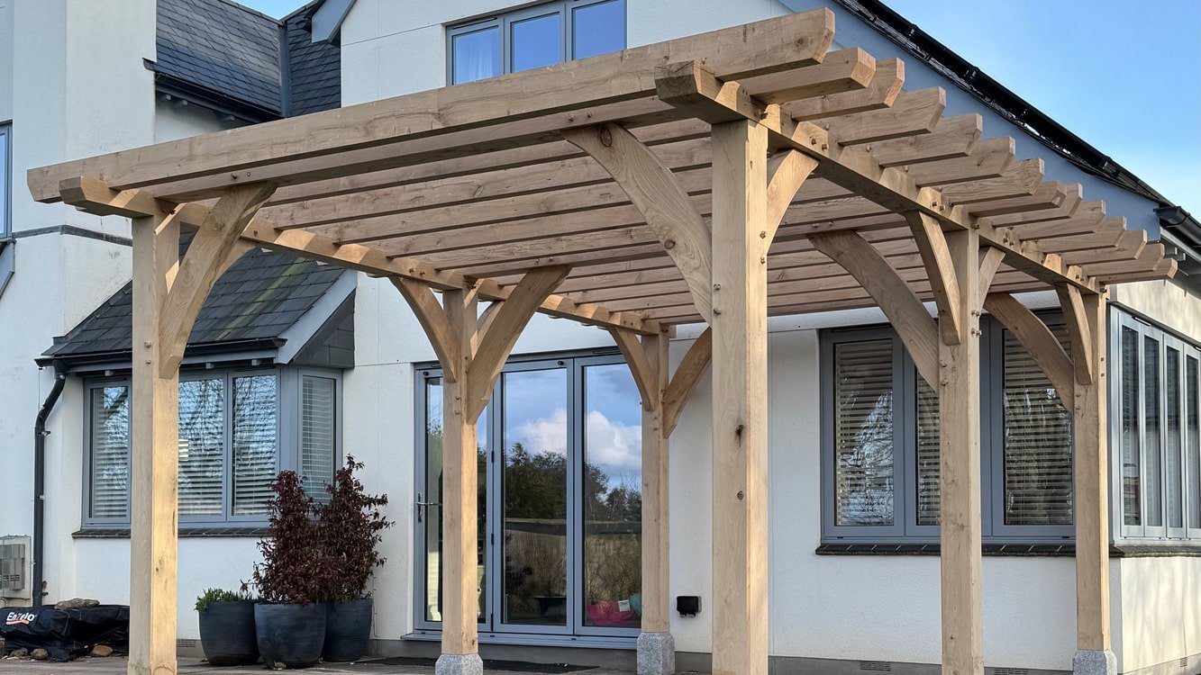 Green oak timber frame porch canopy with cedar shingle roof