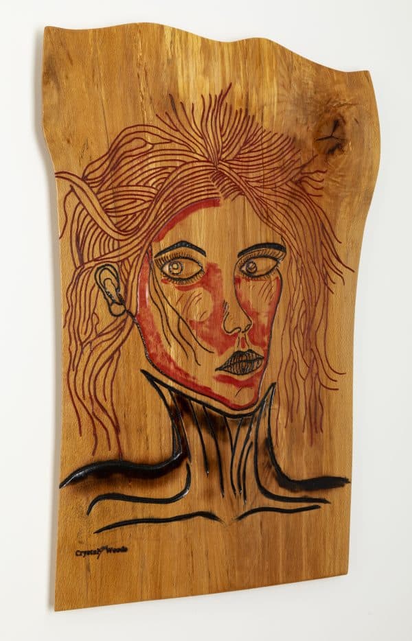 Wooden wall art of the piece titled, Victim of Fashion carved and painted onto a piece of locally sourced English Beech, created by Crystal Woods