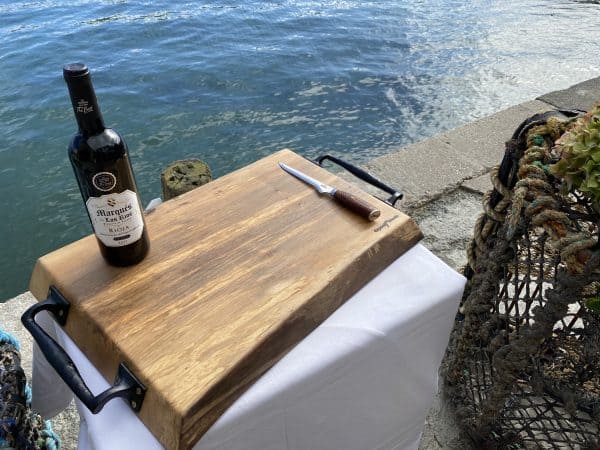 sycamore chopping board displayed on a waterfront with a bottle of wine and knife