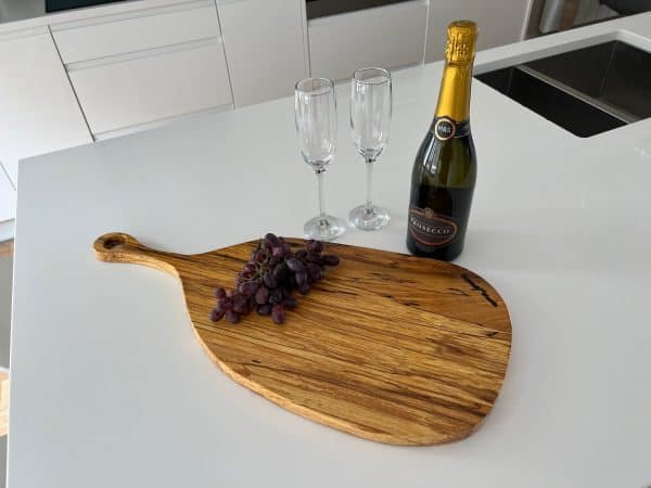 Paddle board pizza tray in Spalted Beech displaying a bottle of wine, grapes and two glasses