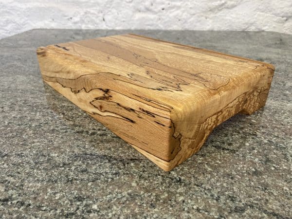 Close up angle view of this Extra Thick chopping board made from locally sourced English Spalted Beech, with two straight flute crumb grooves, created by Crystal Woods, finished in food safe oil, branded with their logo stamp