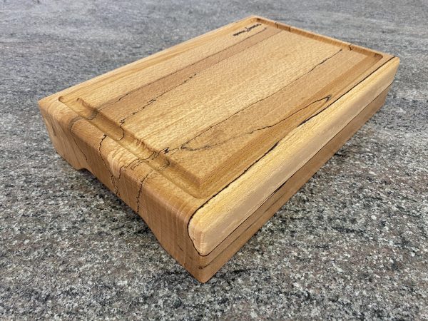 Angled view of this Extra thick Spalted Beech Chopping Board with a Continuous Crumb Groove, handcrafted by Crystal Woods from locally sourced wood in Devon, finished in food safe oil, branded with their logo stamp
