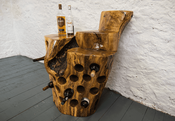 Tree stump driftwood wine rack made from spalted ash with holes for 19 bottles, preserved and finished in multiple coats of oil, handcrafted by Crystal Woods, showing some bottles in the holes