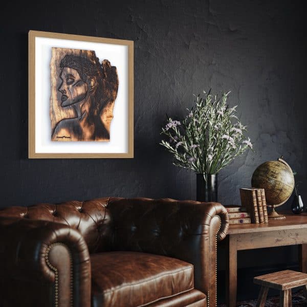 Fine Art Giclee Print, limited edition of the Original Piece – Alignment and Composure of a Goddess, illustrated in a gold wood coloured frame with white background set on a black textured wall above a leather chesterfield arm chair