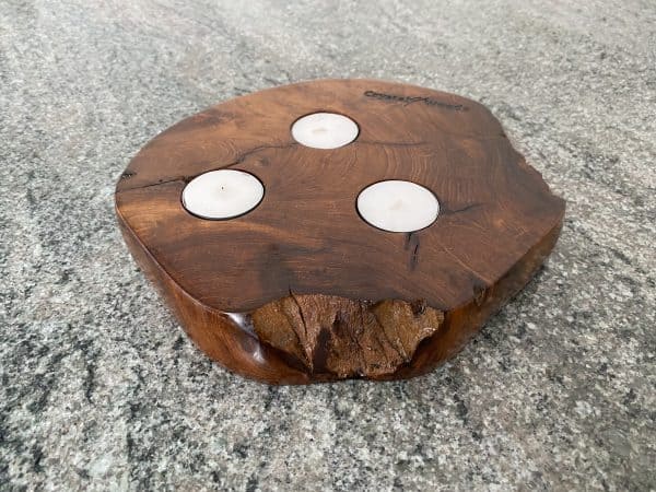 A piece of Indonesian Teak holding 3 tea lights with deep rich grain colour and texture, finished in multiple coats of oil