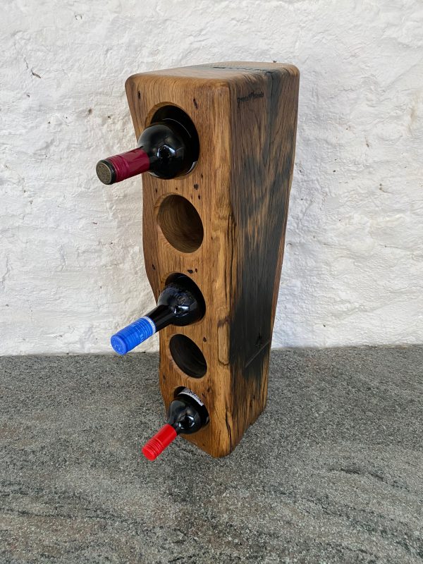 A piece of reclaimed French Oak Railway Sleeper that's been transformed into a chick 5 bottle wine rack displaying bottles in the holes