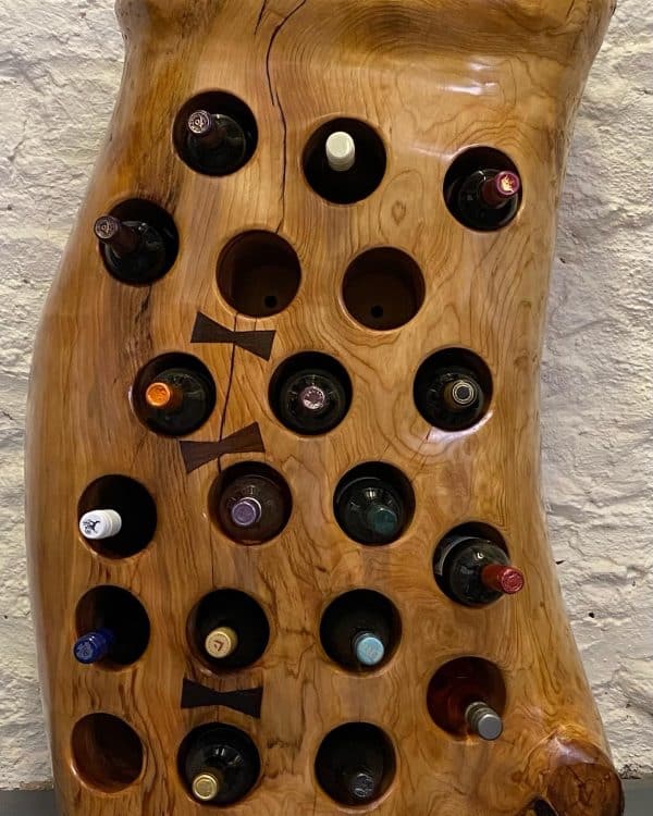 Front on display of a magnificent Tree Trunk Wine Rack in Lebanese Cedar that holds 20 bottles showing the wine in the inserted holes