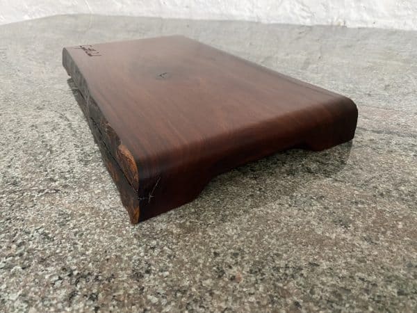 A rolled end top chopping board in African Pau Rosa wood, handcrafted by Crystal Woods